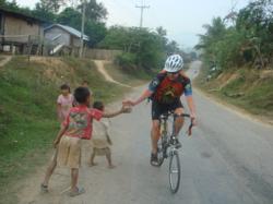 Friendly children and cyclist in Laos